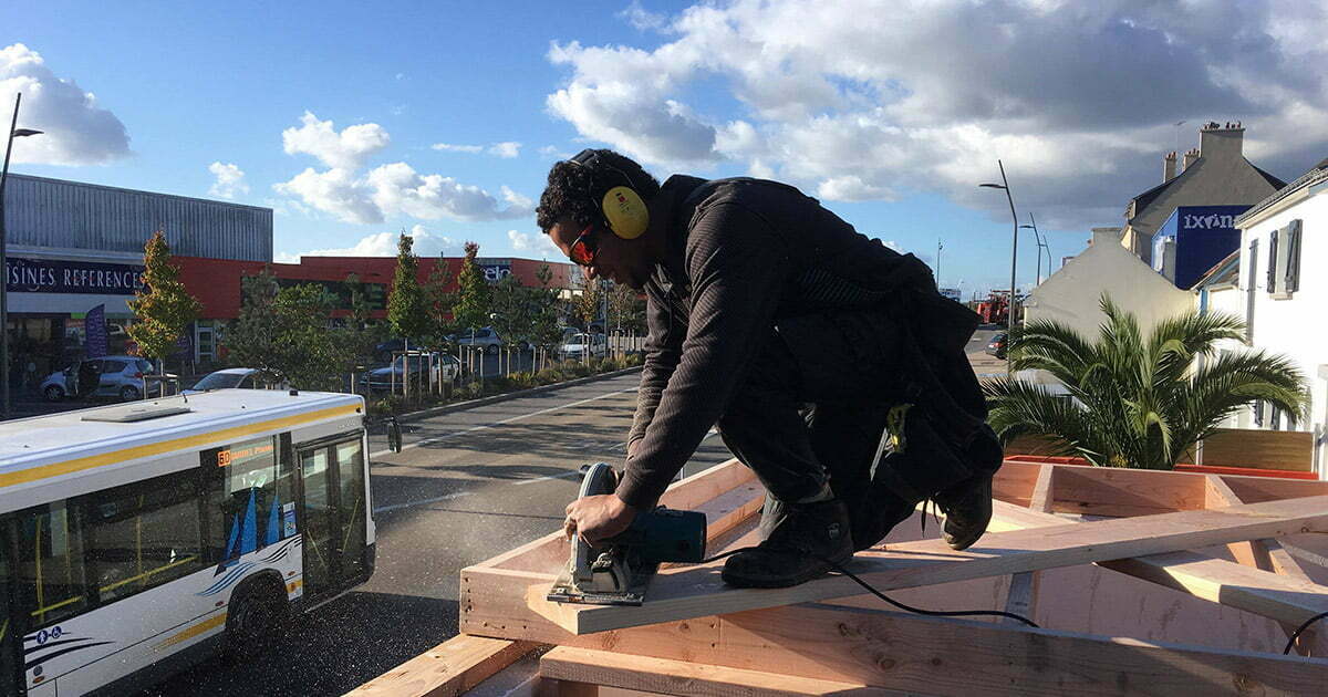 ismael charpentier travaille sur les toits avec son pantalon de travail